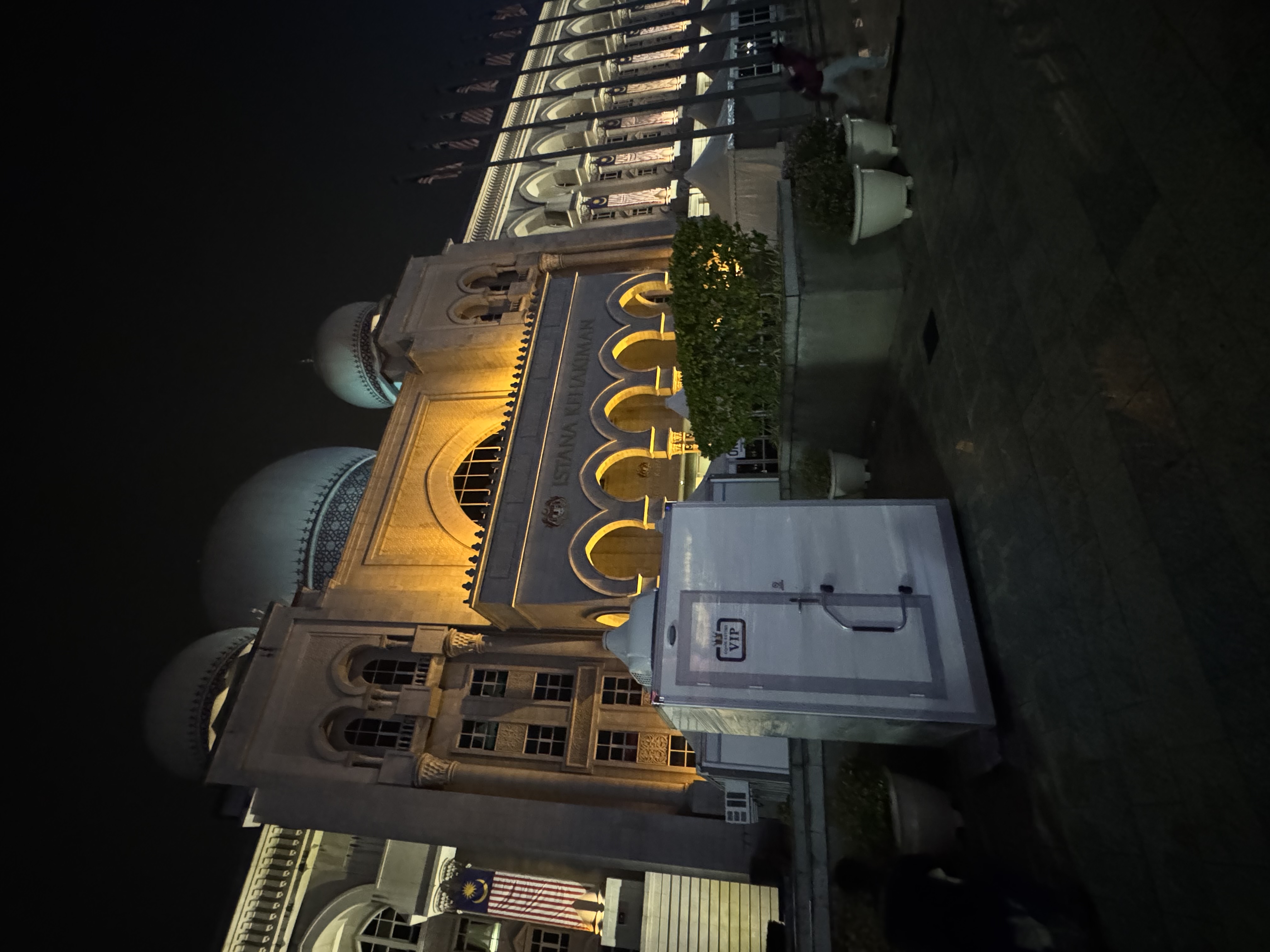 EQool VIP cabin toilet in front of the illuminated Istana Kehakiman at night during Hari Kebangsaan 2025